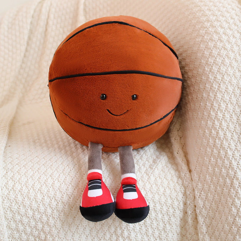 Plush toy basketball with a face and legs on a beige blanket