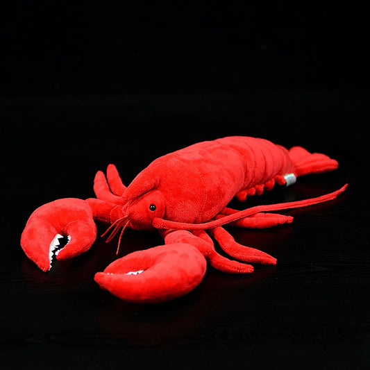 Red plush lobster toy on a black background