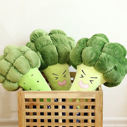 Plush broccoli toys with smiling faces in a wooden basket on a light background