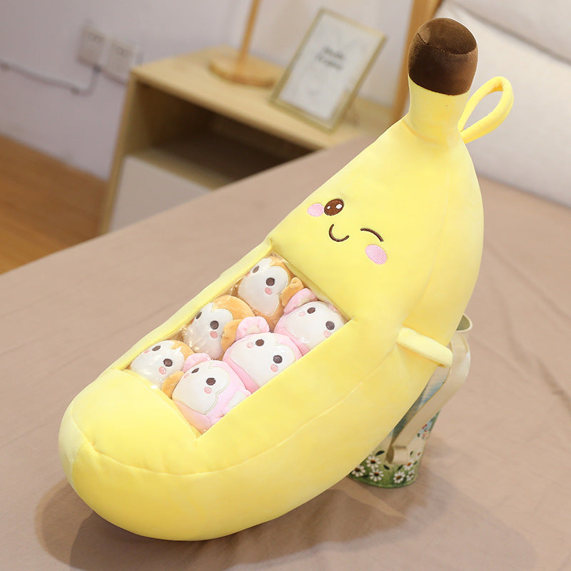 Banana-shaped plush toy with small plush toys inside on a bed