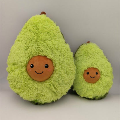 Two plush avocados with smiling faces on a plain background