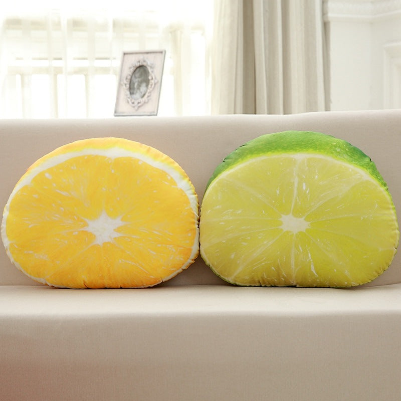 Two round pillows shaped like lemon and lime slices on a couch.