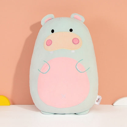 Hippo-shaped pillow with pastel colors on a peach background
