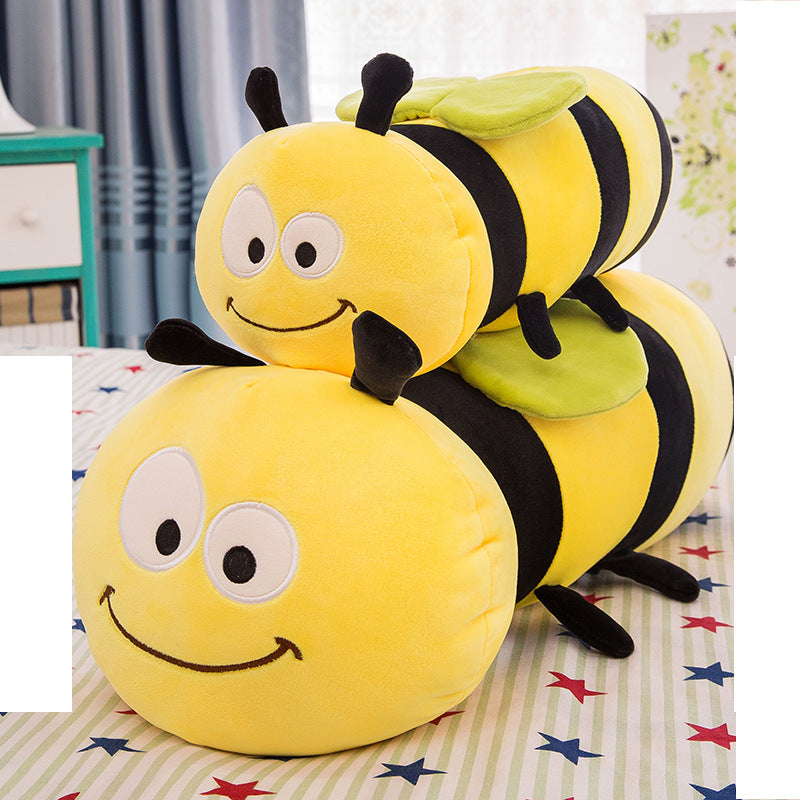 Plush toy shaped like a bee on a bed with colorful stars.