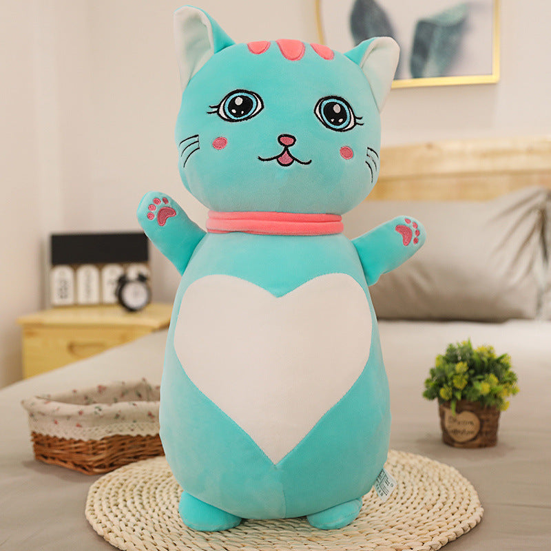 Blue plush cat toy with a white heart on a bed in a bedroom setting