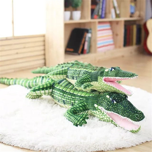 Two green crocodile plush toys on a white rug with a wooden shelf in the background.