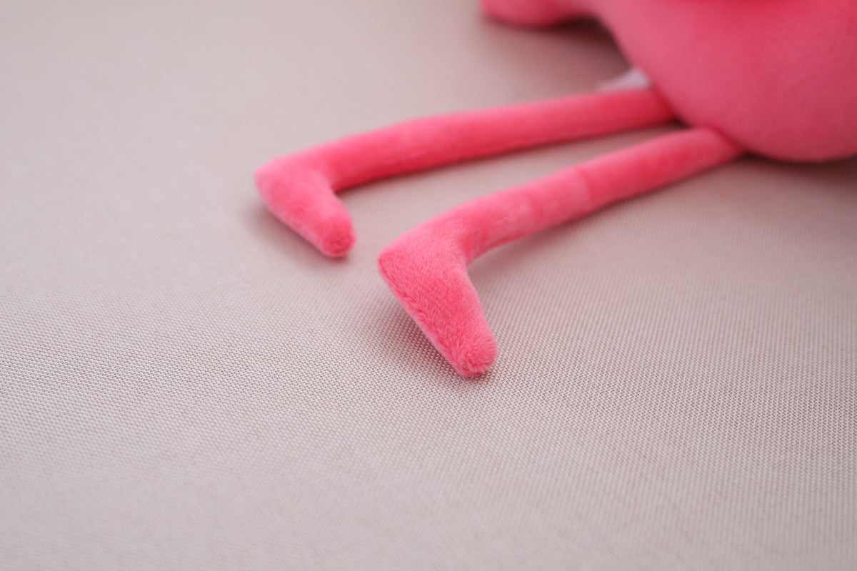 Close-up of a pink plush toy on a beige surface